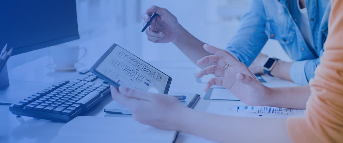 Designers reviewing a tablet interface together.