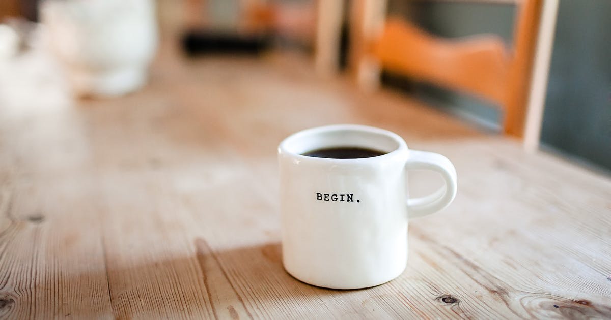 Coffee mug titled BEGIN on dining table to demonstrate it's time to start contracting