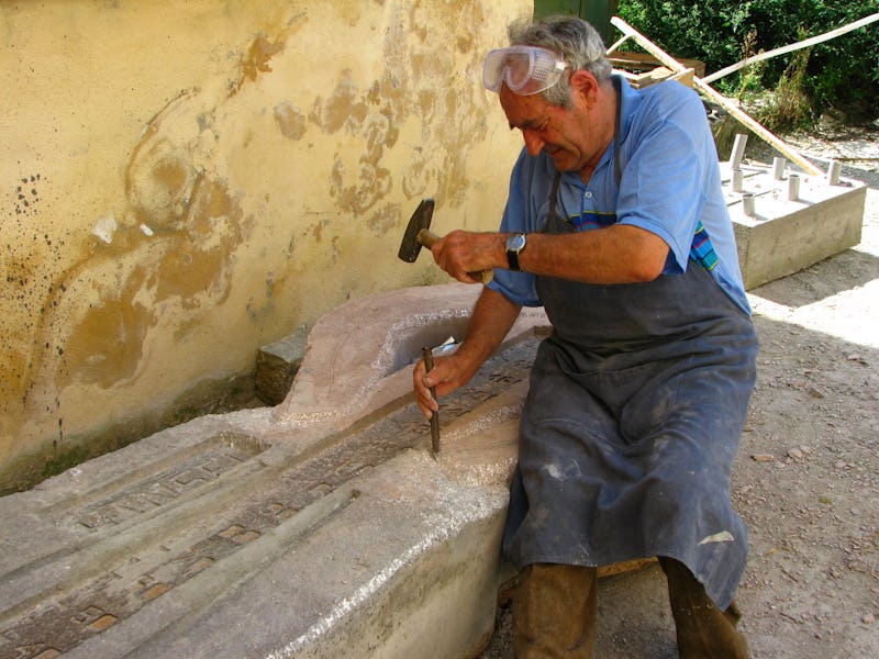 Emil Mureșan în timp ce sculptează în piatră