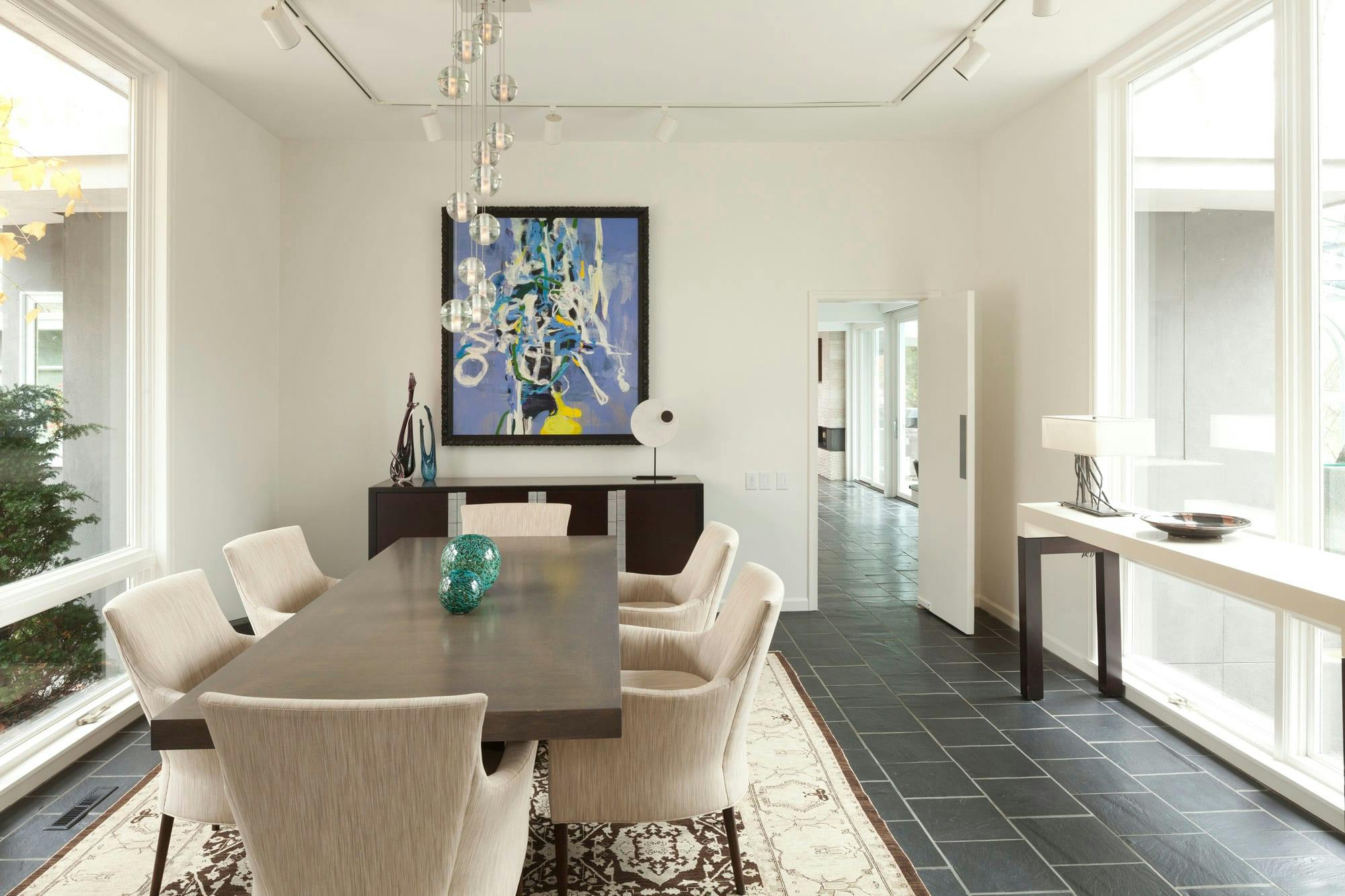 dining room with great art, lighting details and comfy dining chairs