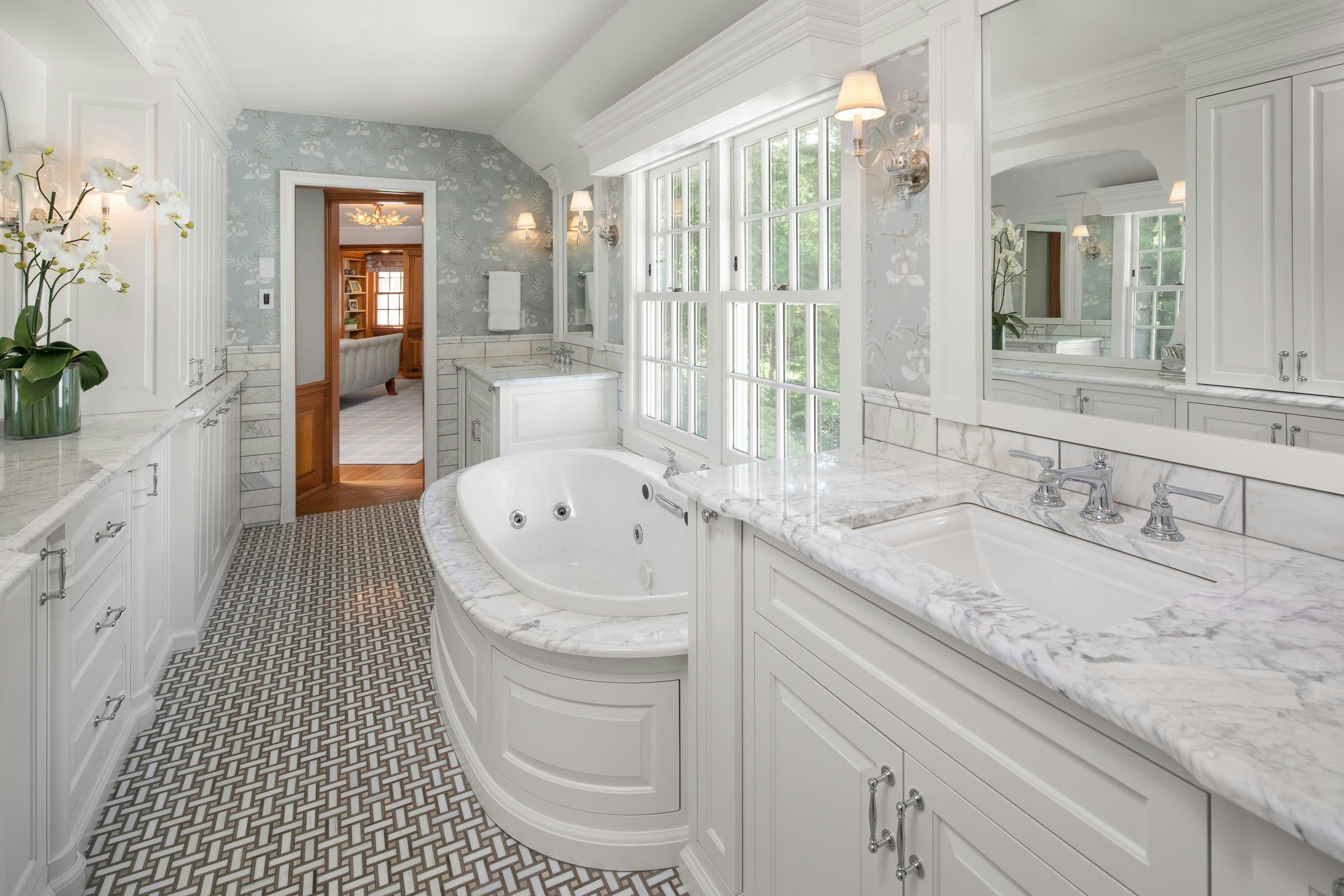 white, marble bathroom, jetted tub, vanity, built-in storage 