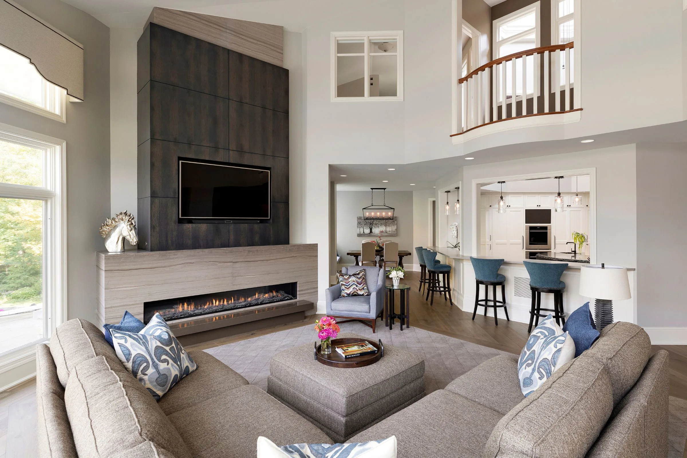 living room with sectional, fireplace, high ceilings 