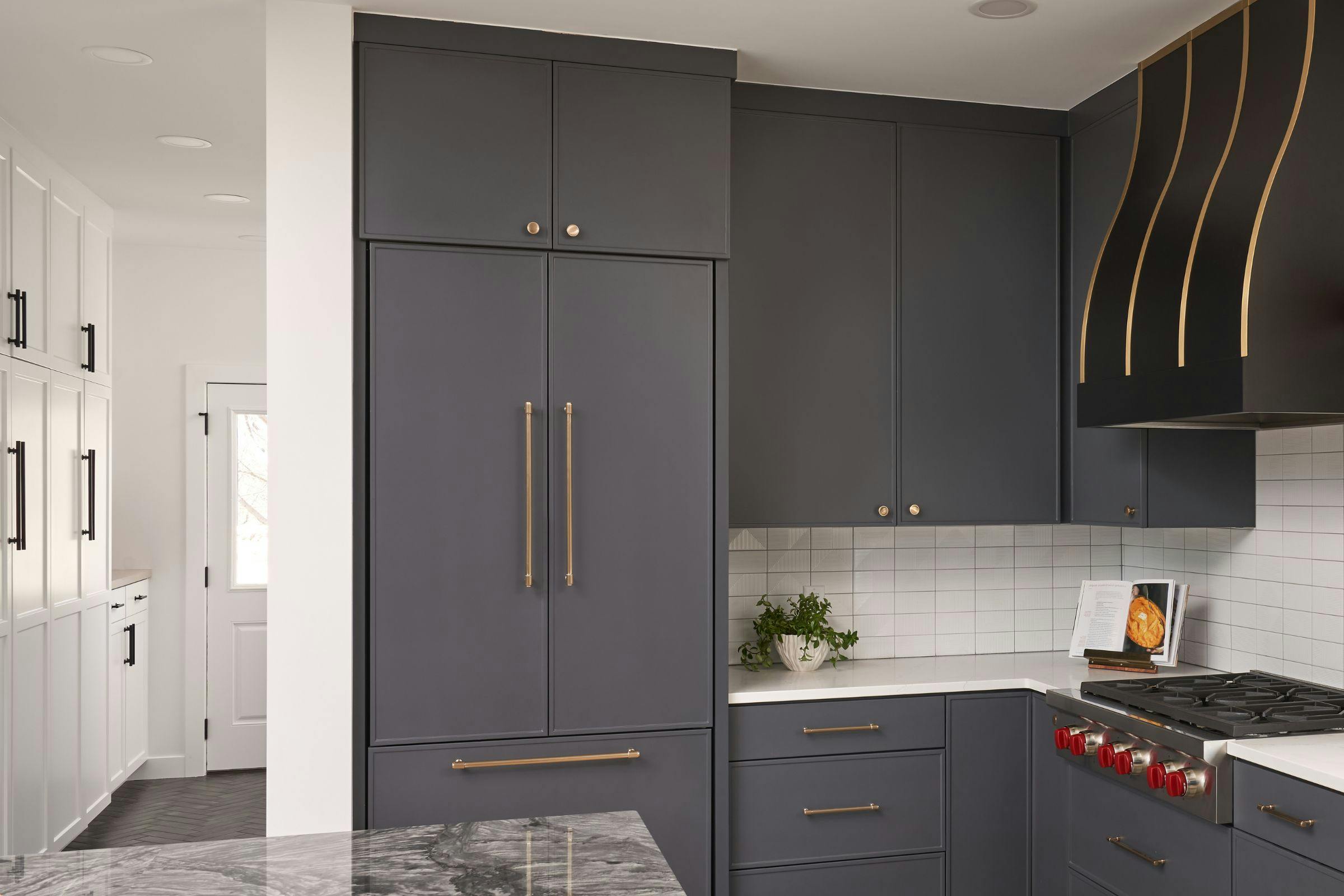 black kitchen leads to white mudroom