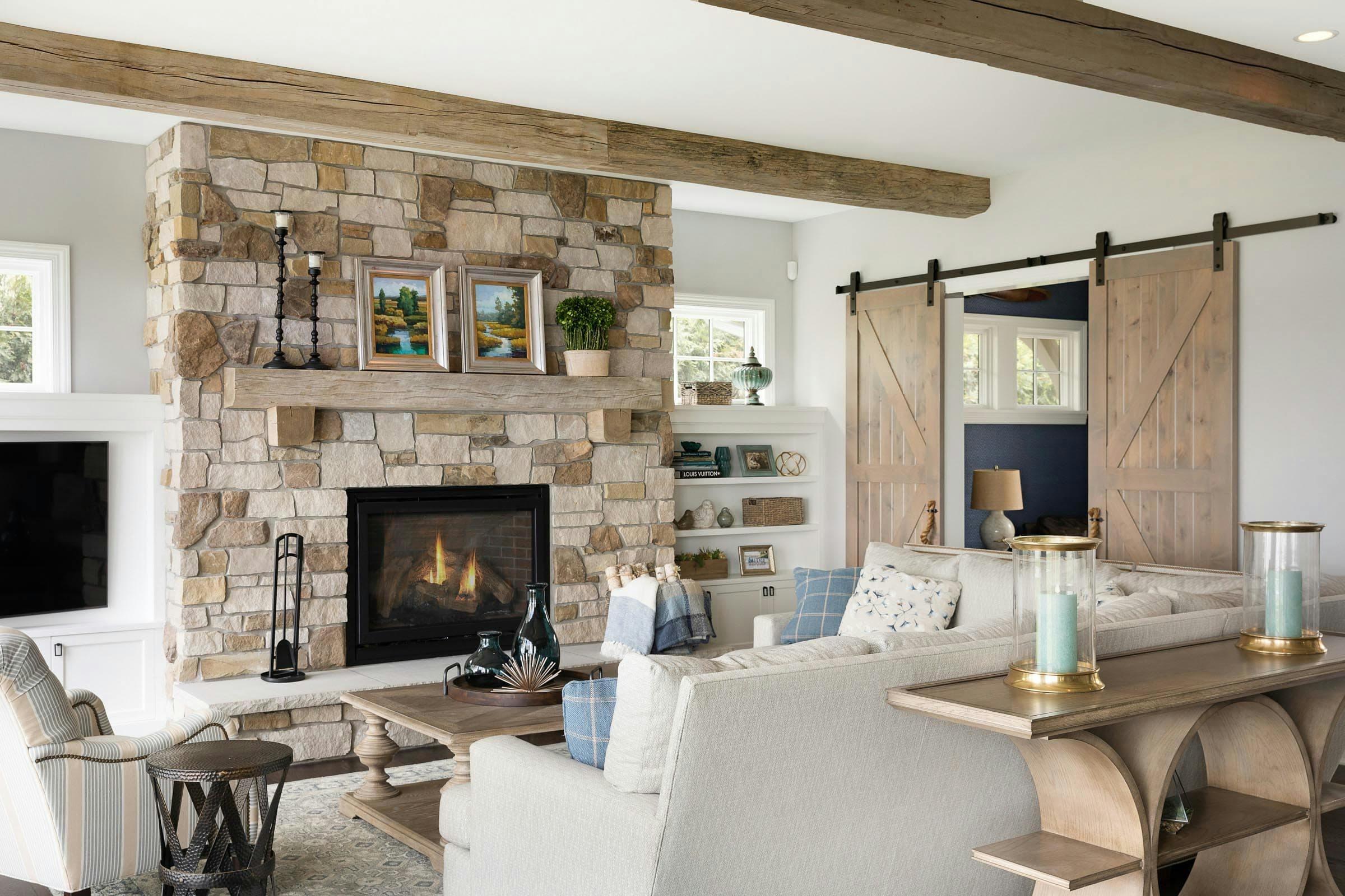 Living room with fireplace and through barn doors is the office