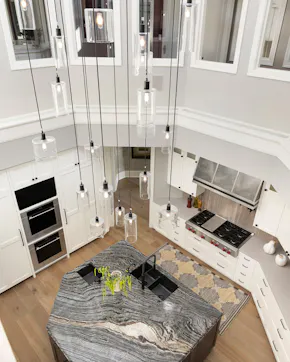 view from above looking at the kitchen, irregular shaped island, sink, oven and hood, white cabinets