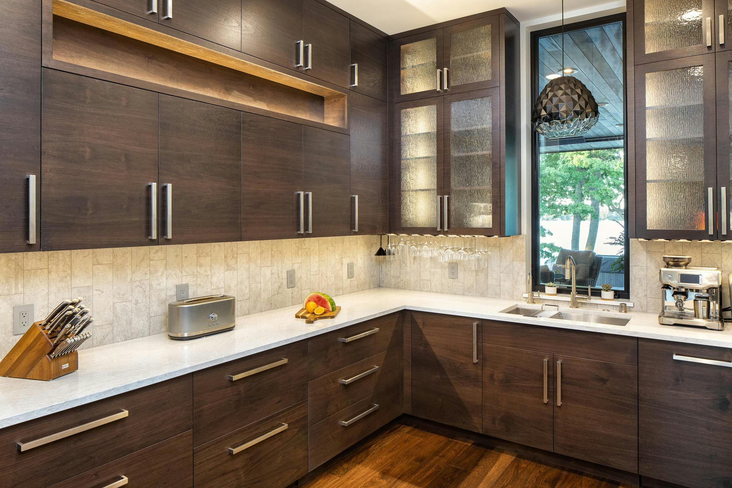 prep pantry with walnut cabinetry and white countertops