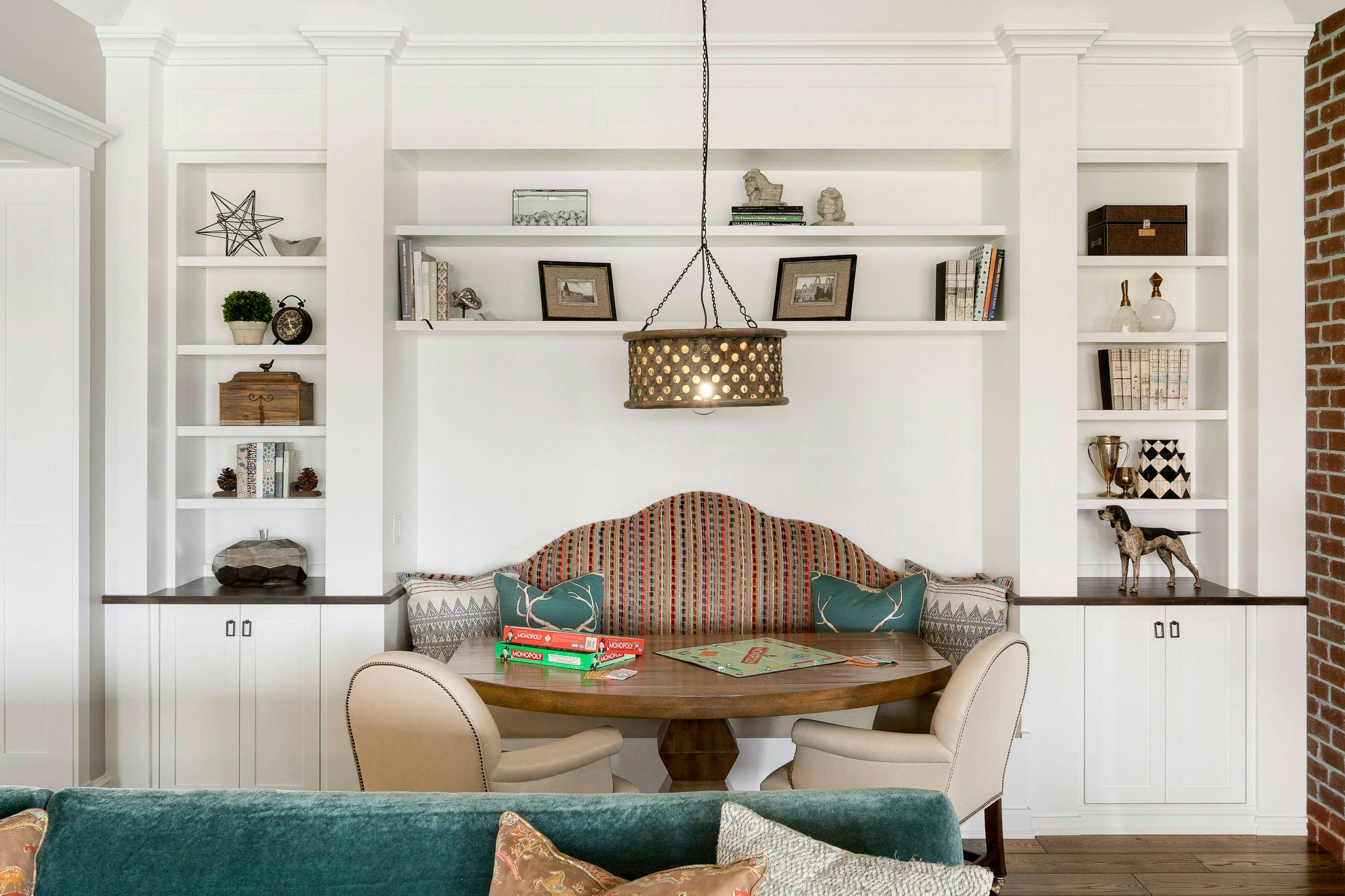 white built-in storage surrounding banquette, booth and chairs