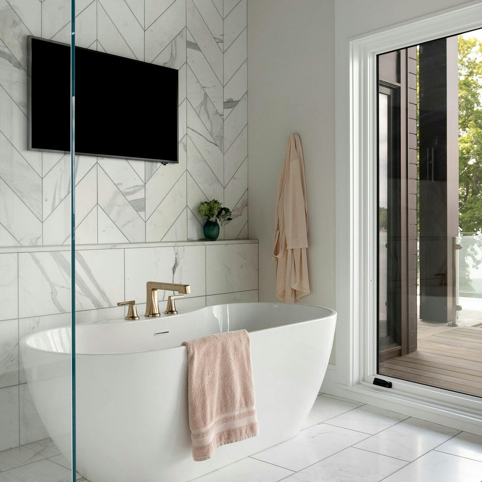 freestanding tub in white bathroom with tv