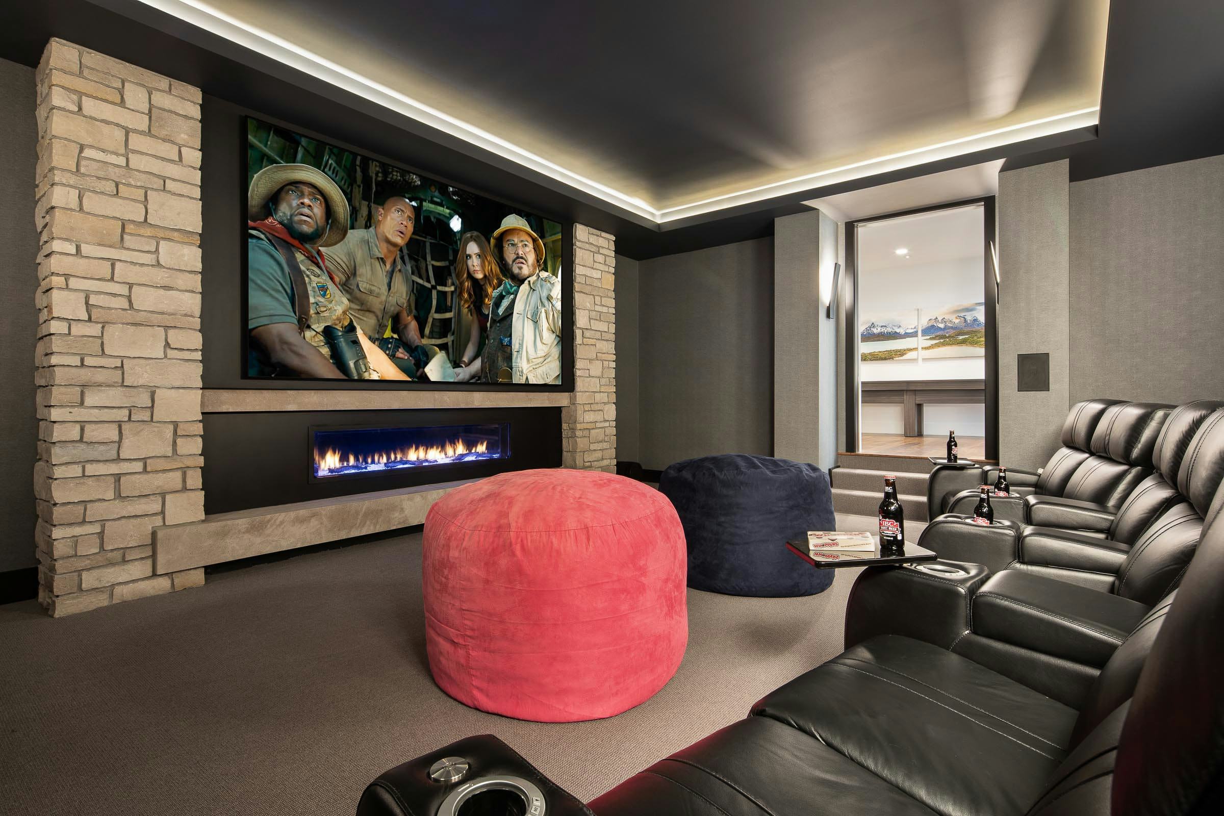 home theater room with large TV, leather seats, pink and blue poof