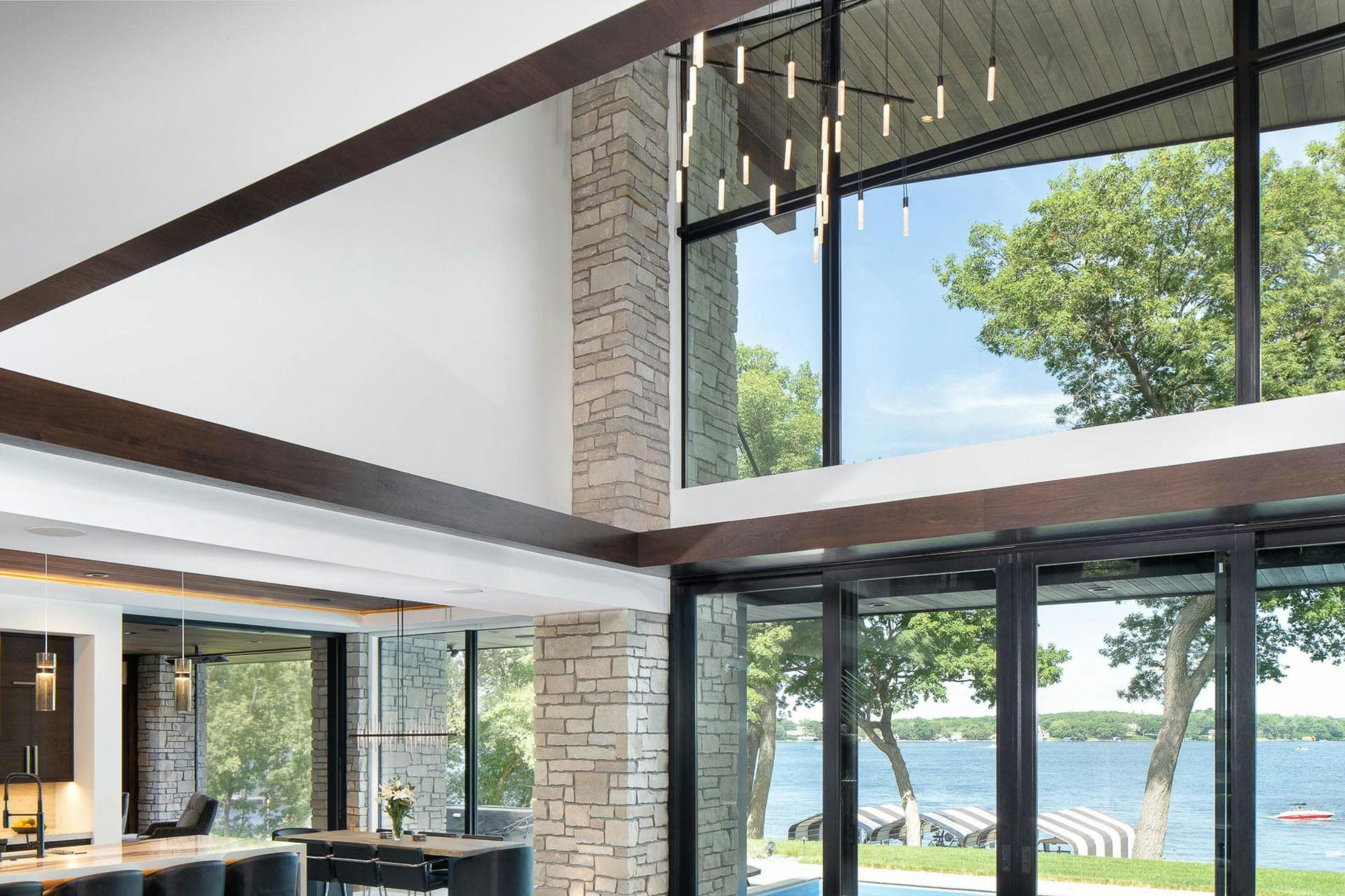 glass windows overlooking the lake, pendant lighting hangs above
