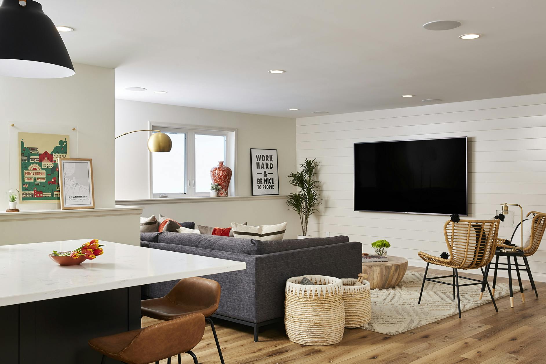 living space with TV, sofa and rattan chairs