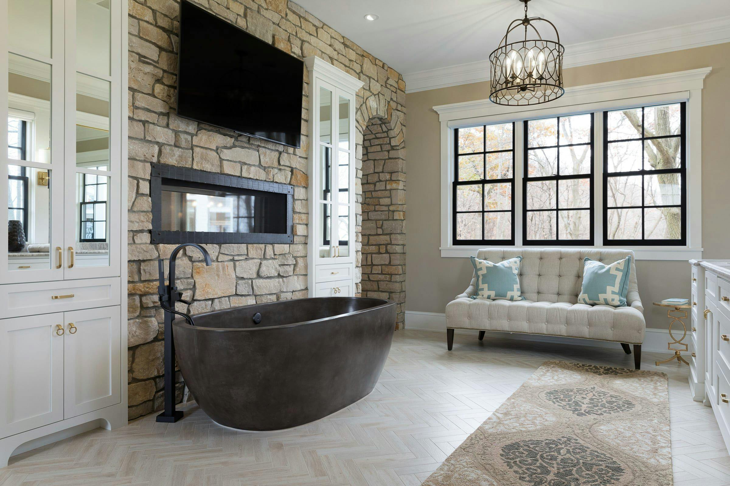 neutral bathroom with concrete tub, TV, and fireplace