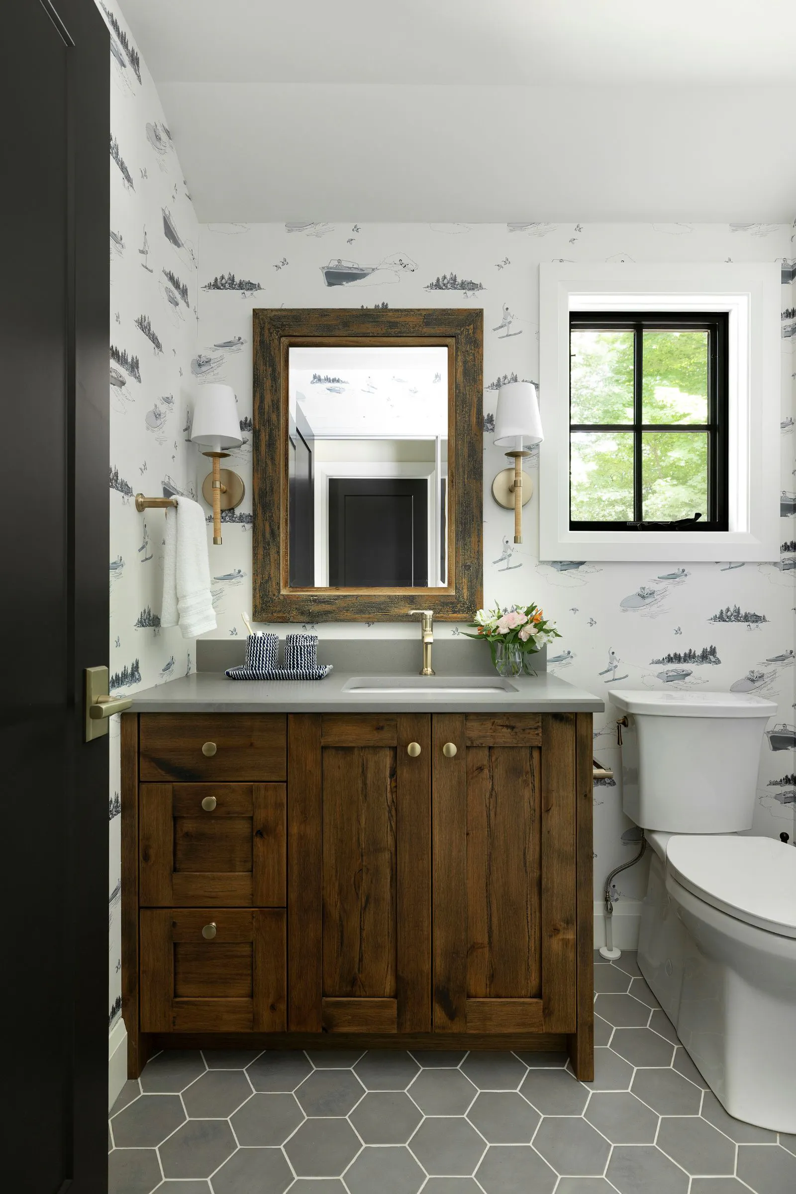 Neutral ensuite bathroom with blue sailboat wallpaper in Wisconsin lake cabin