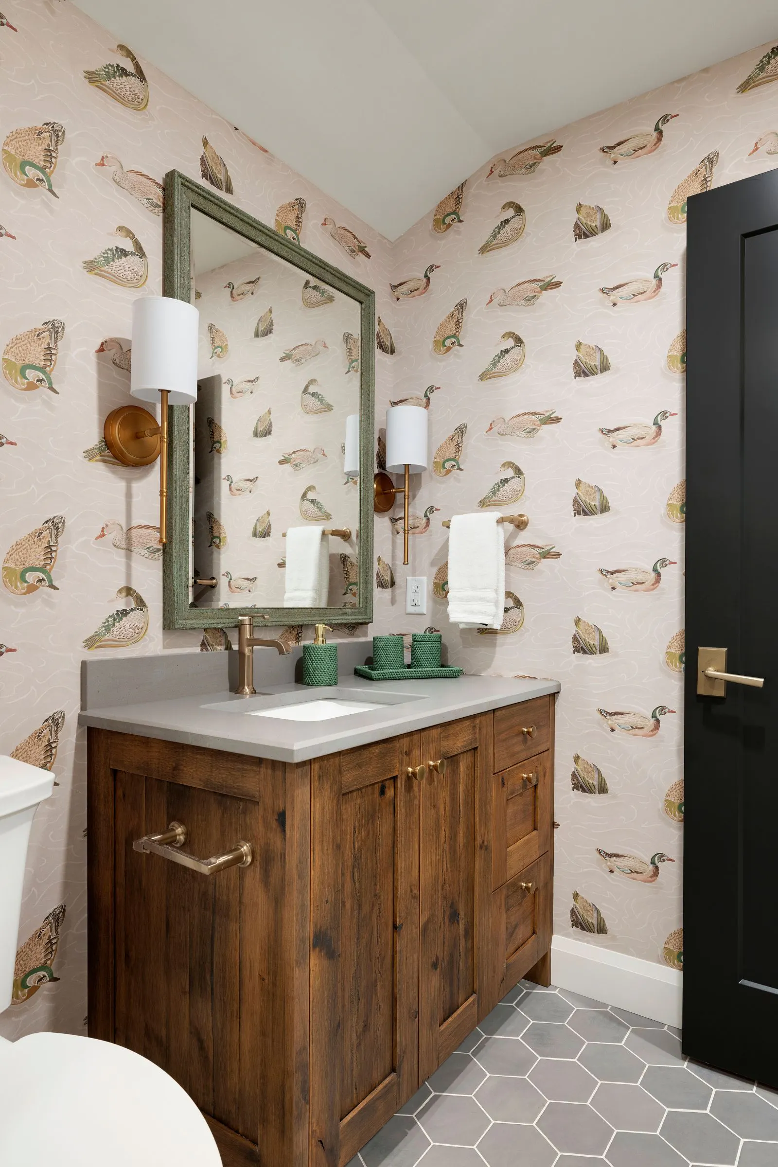 Pink ensuite bathroom with duck wallpaper and neutral finishes