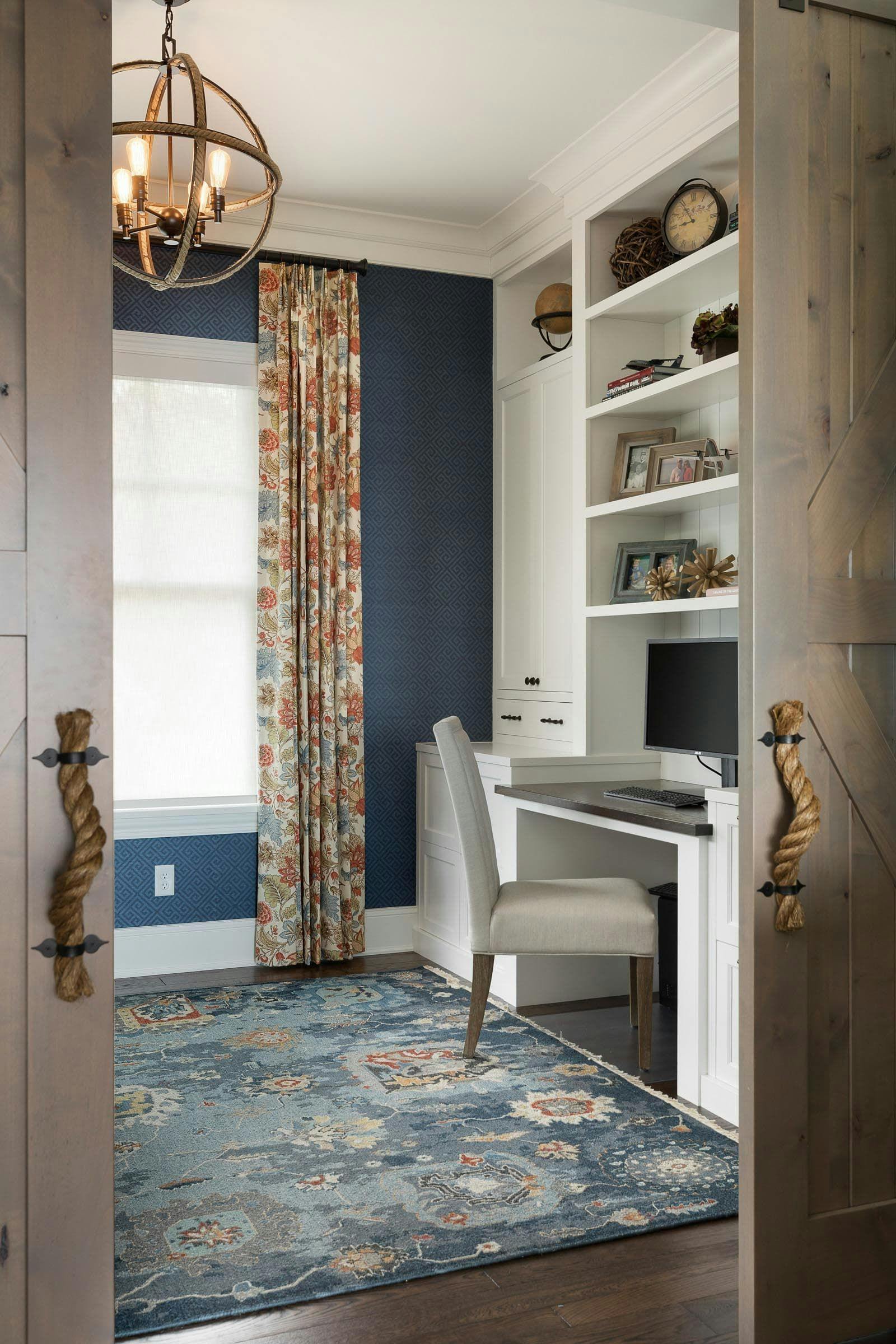 blue office with floral curtains and white built above a desk