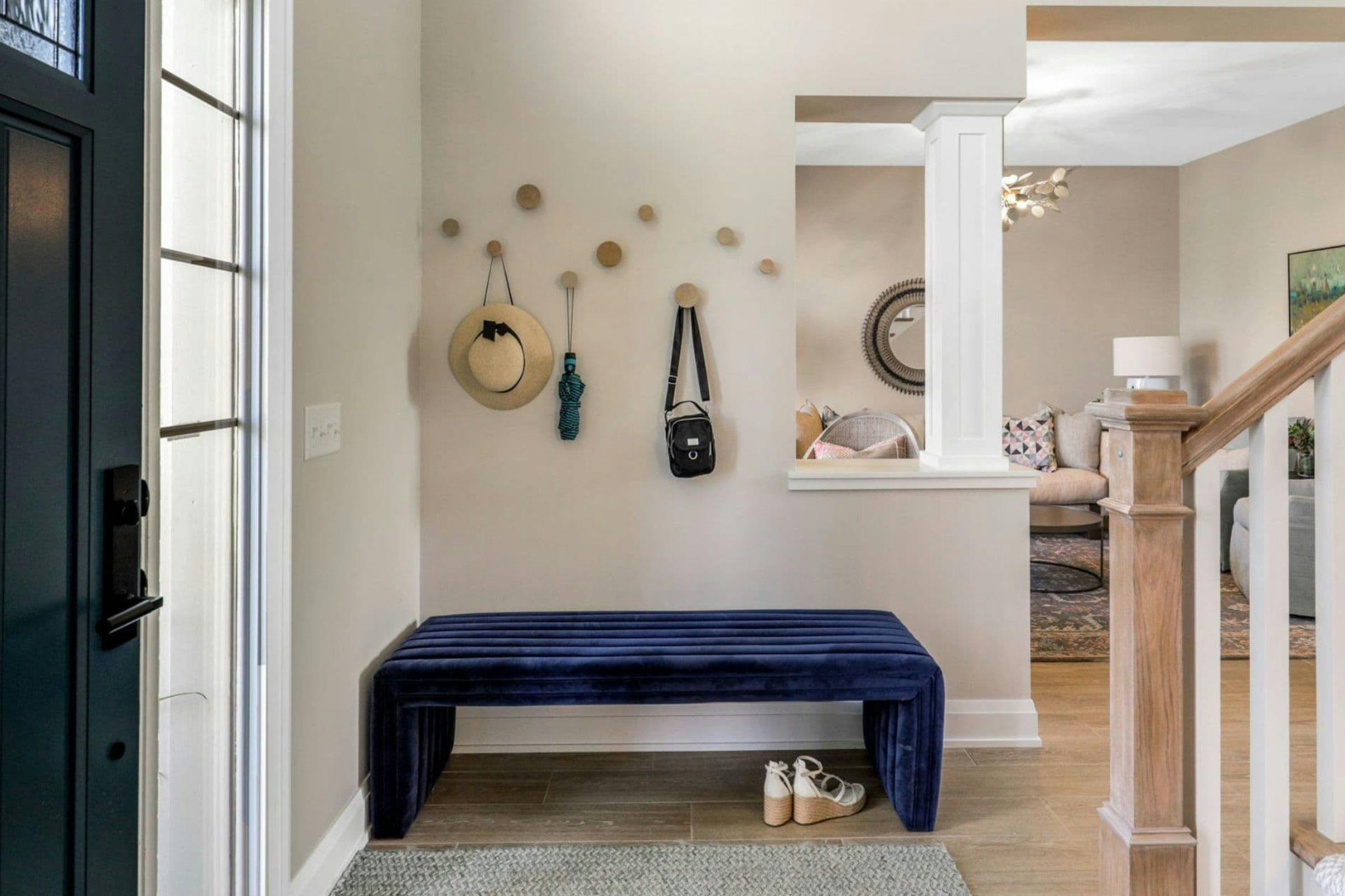 entryway with blue velvet bench and hooks above