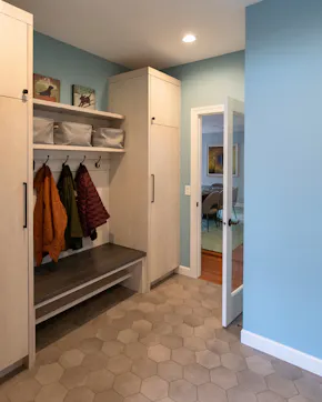 bench, storage closets, hooks with jackets