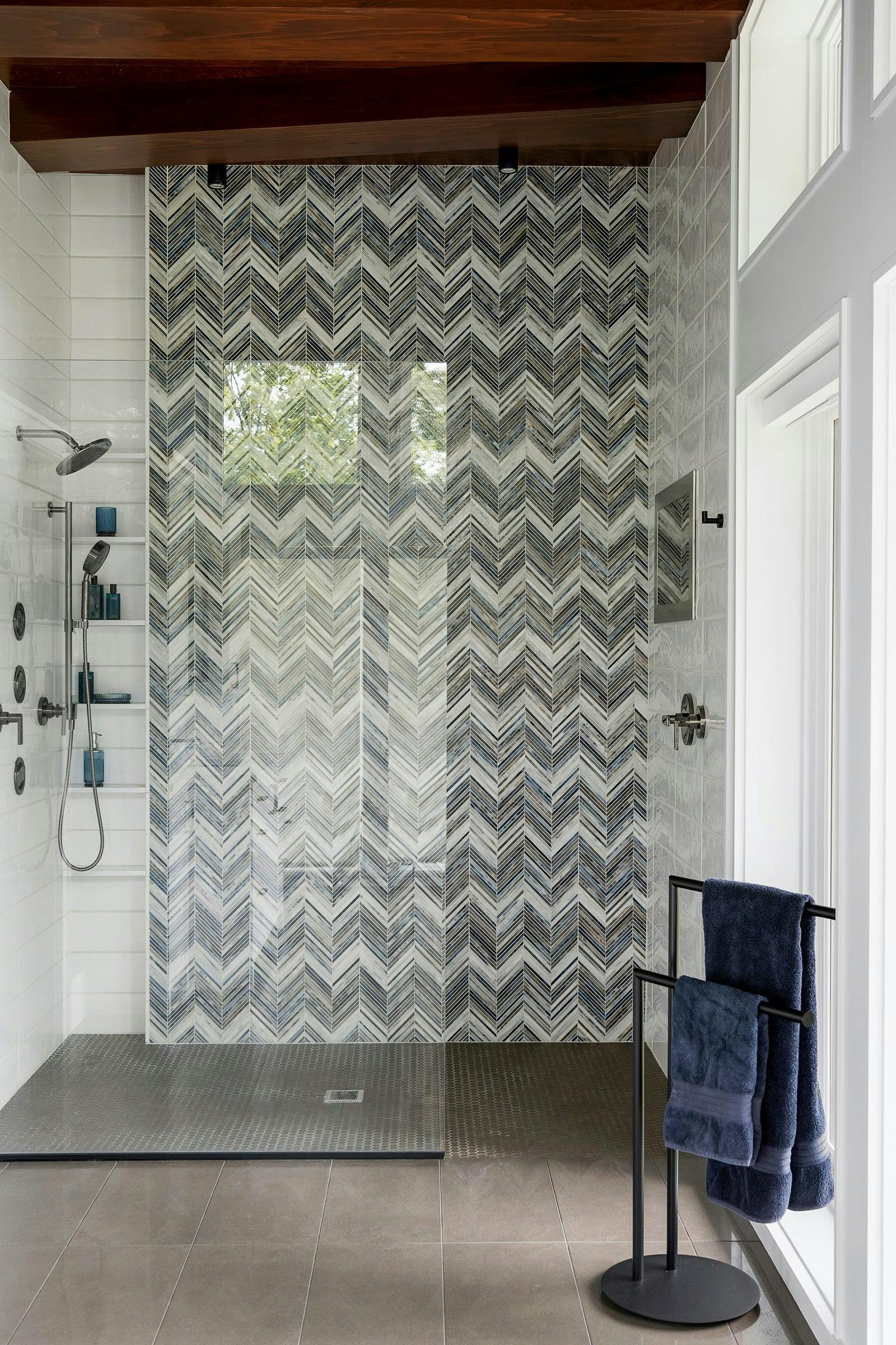 walk-in glass shower with a zig-zag tile feature wall