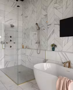 large glass walk-in shower and soaking tub