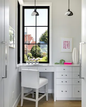 Hidden home office behind cabinetry near kitchen in sleek modern home design