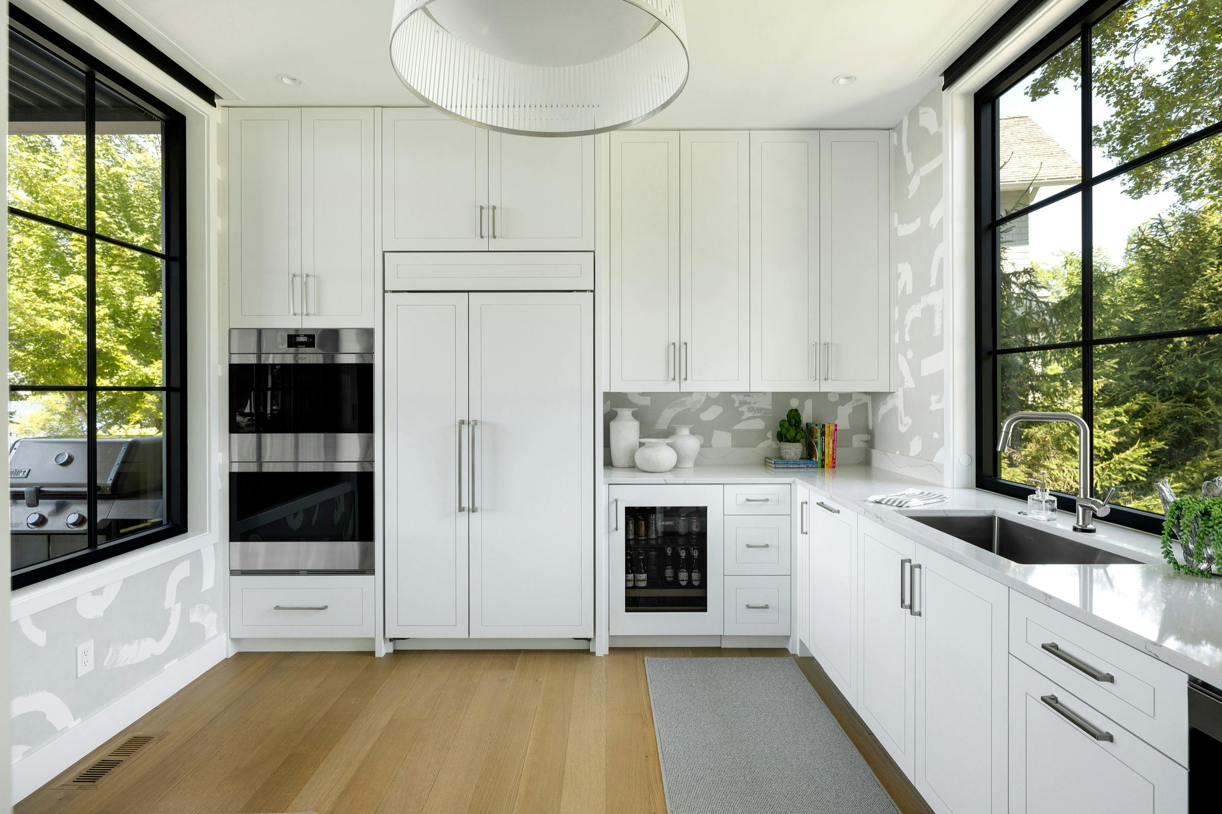 Modern kitchen with hidden pantry and prep kitchen access in custom Lake Minnetonka new build