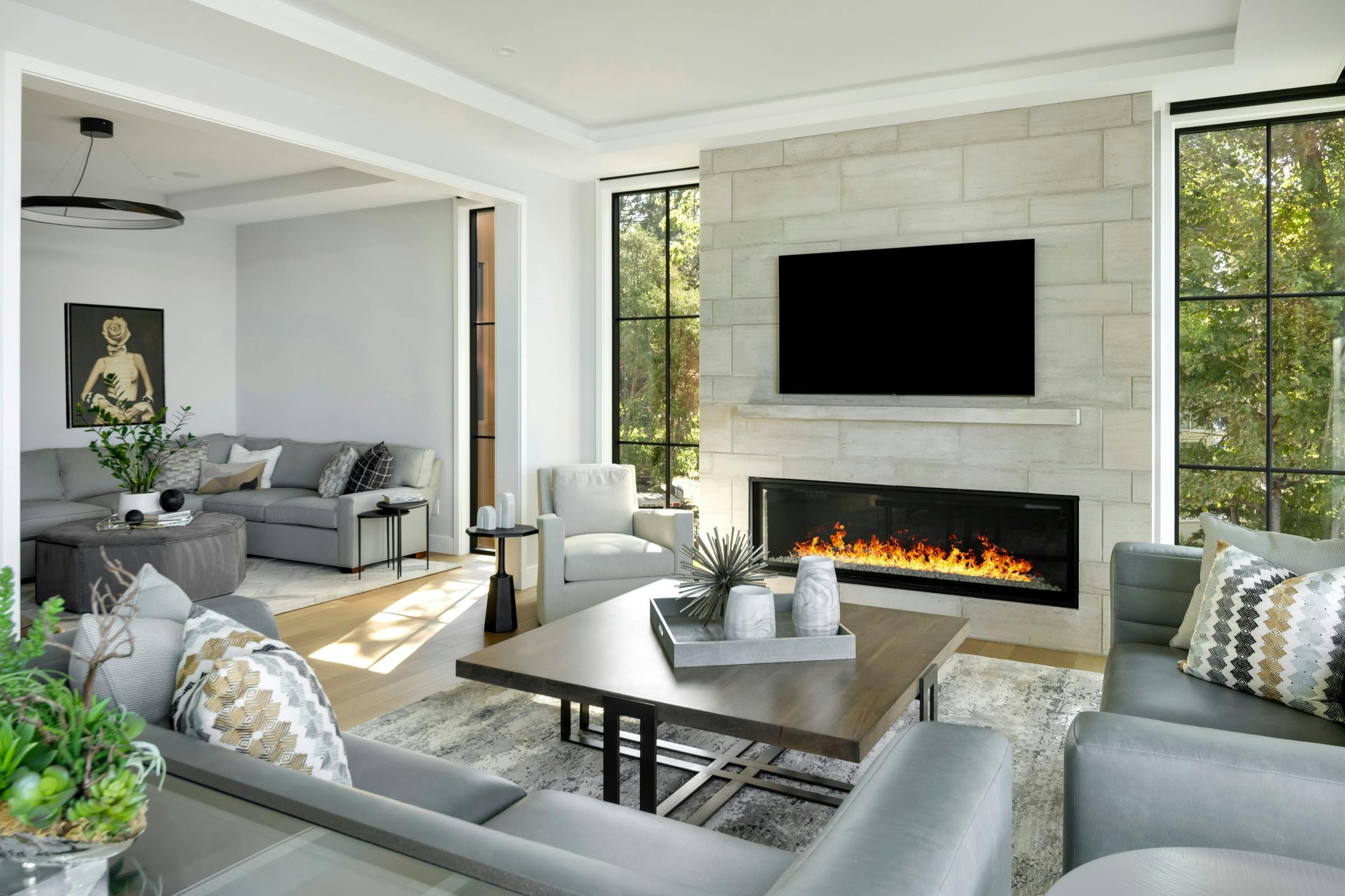 Stone fireplace with lake views and clean-lined seating area in Lake Minnetonka new home