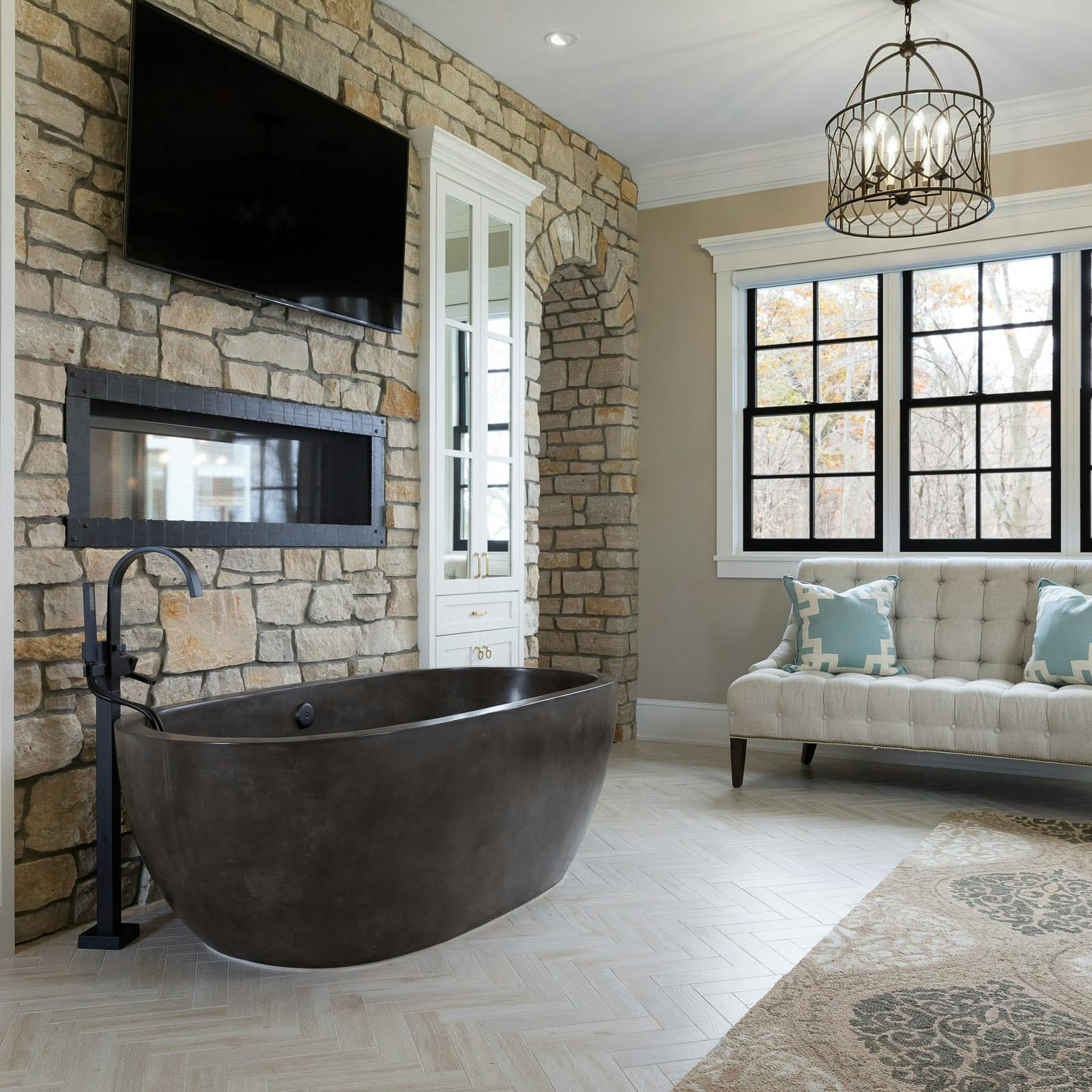 bathroom with concrete standing tub, TV, fireplace and seating