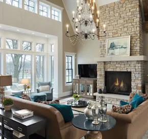 brick fireplace, chandelier and sofas in a great room