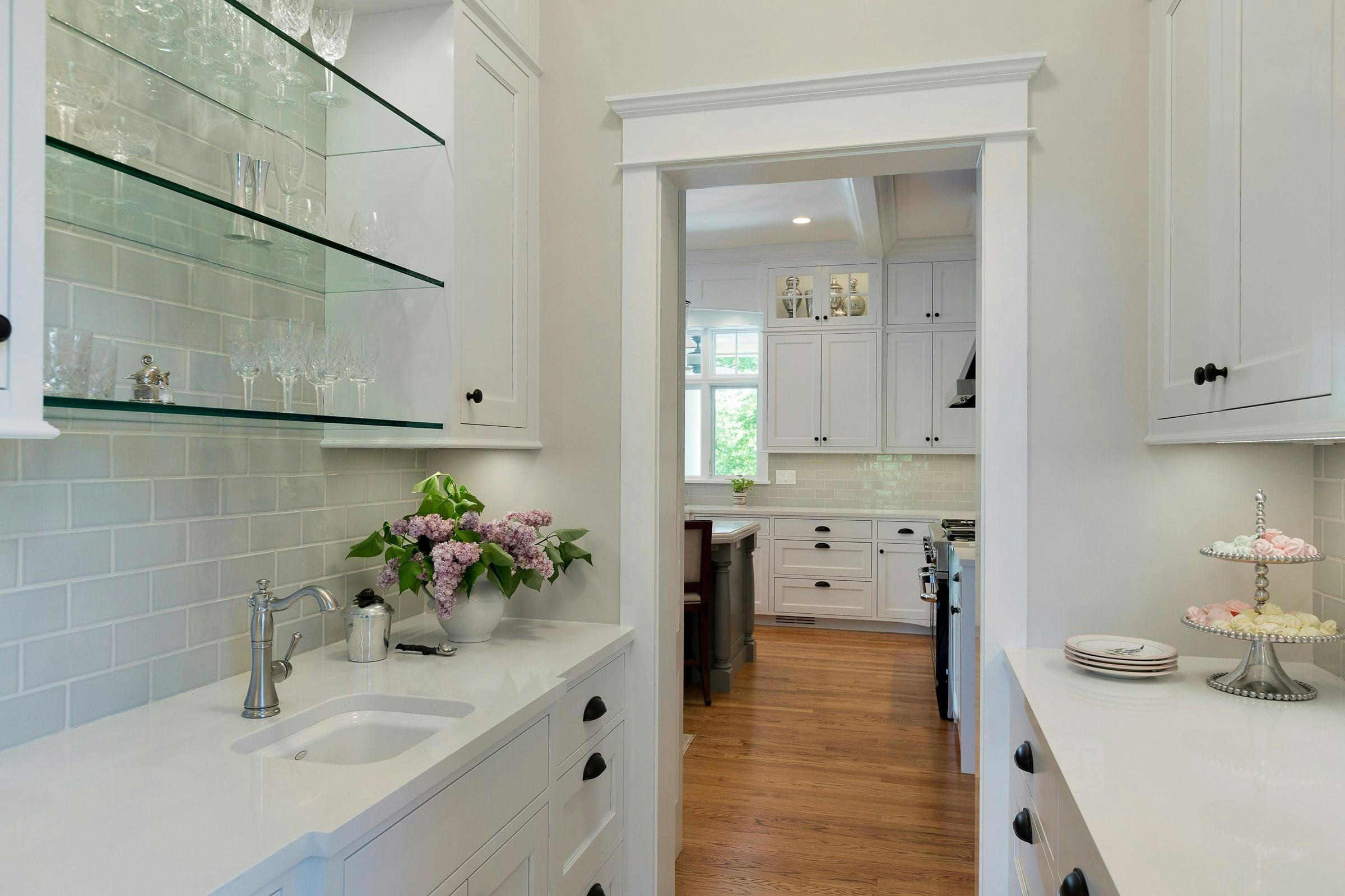 white cabinets and glass shelves, small sink