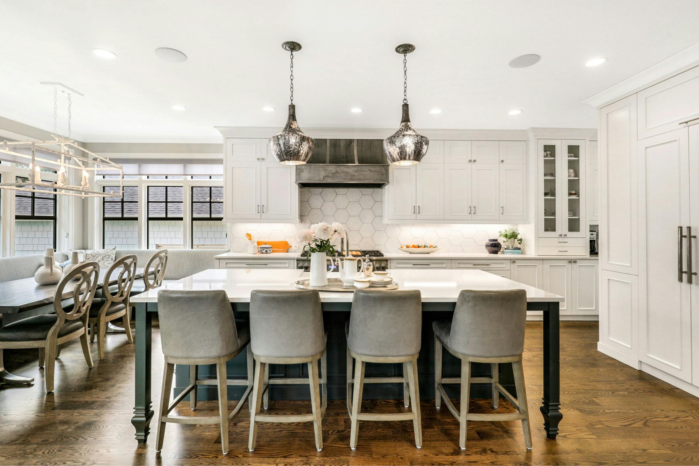 kitchen island with four chairs and pendant lighting above