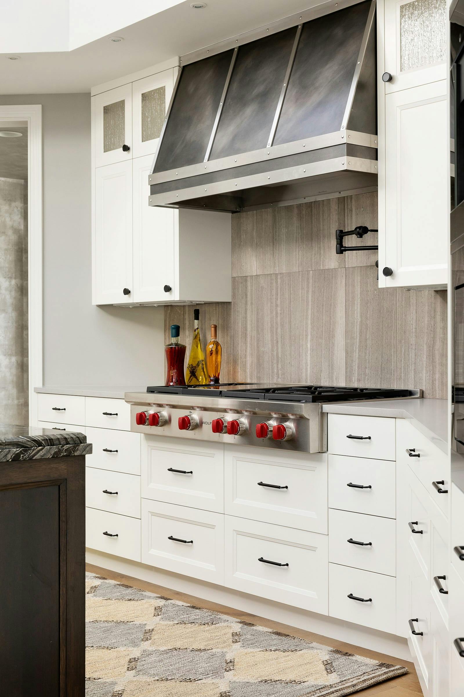 white drawers and upper cabinets, stove top and hood