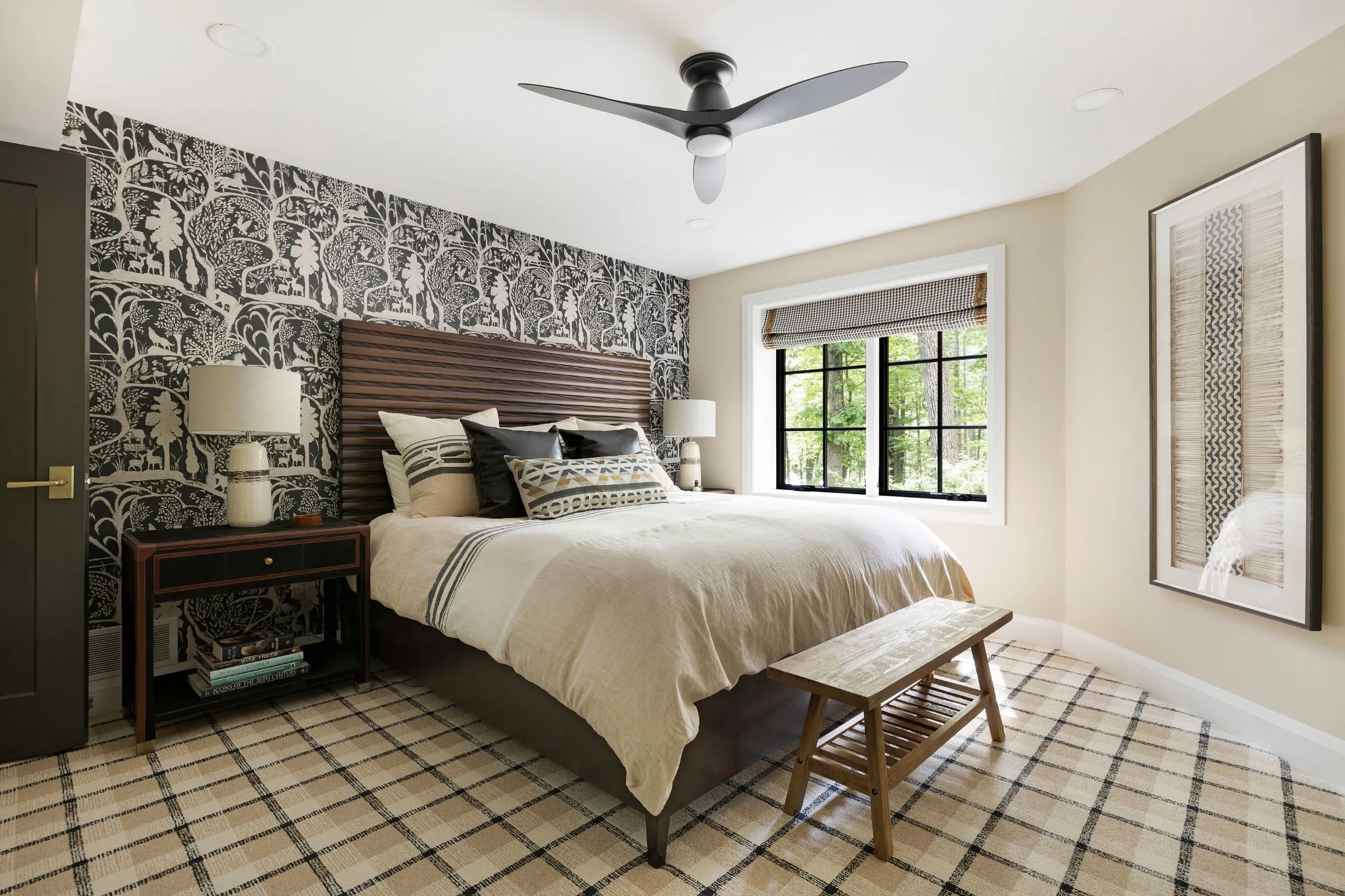 Black and cream guest bedroom with patterned feature wall and warm design details