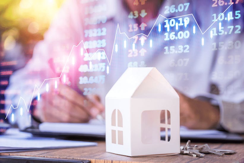 A picture of a small house and a stock market