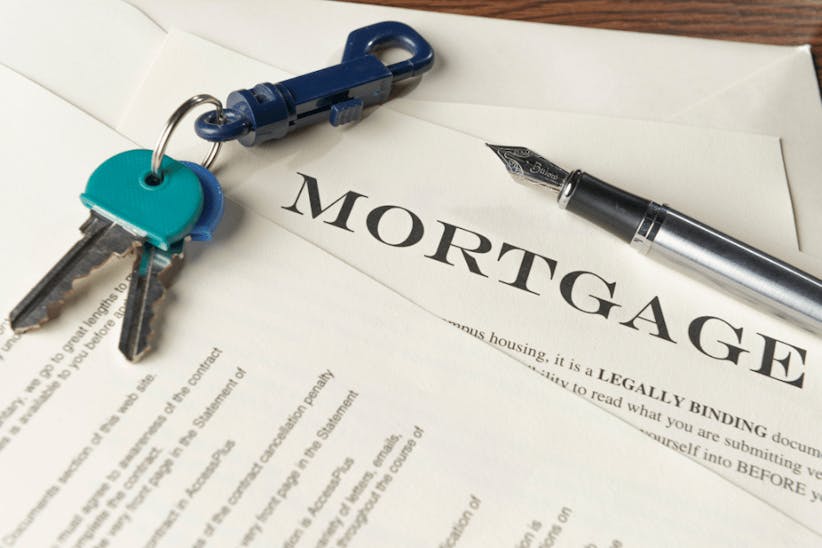 A picture of a keys and a mortgage contract