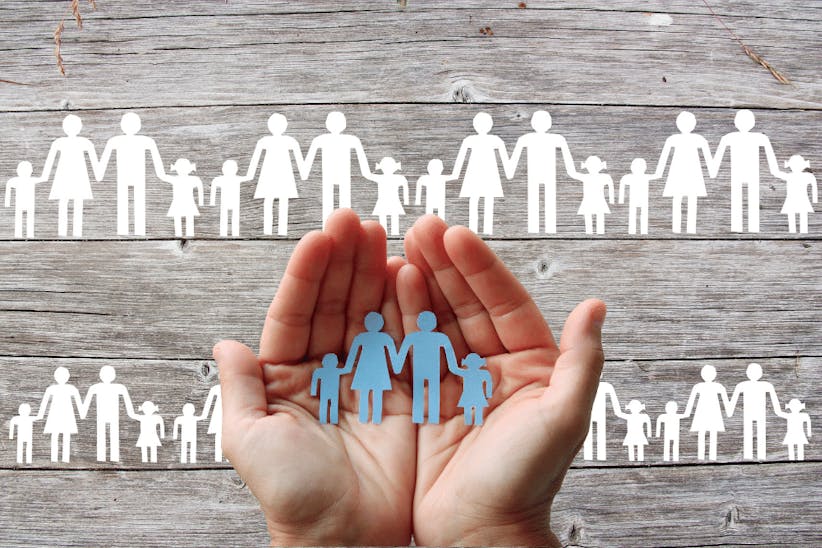 A picture of a hands holding a small figures of people