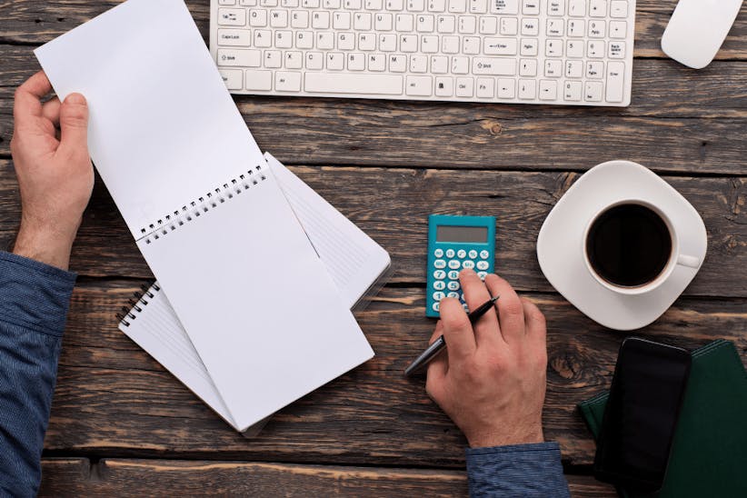 A man using a calculator and a paperpad