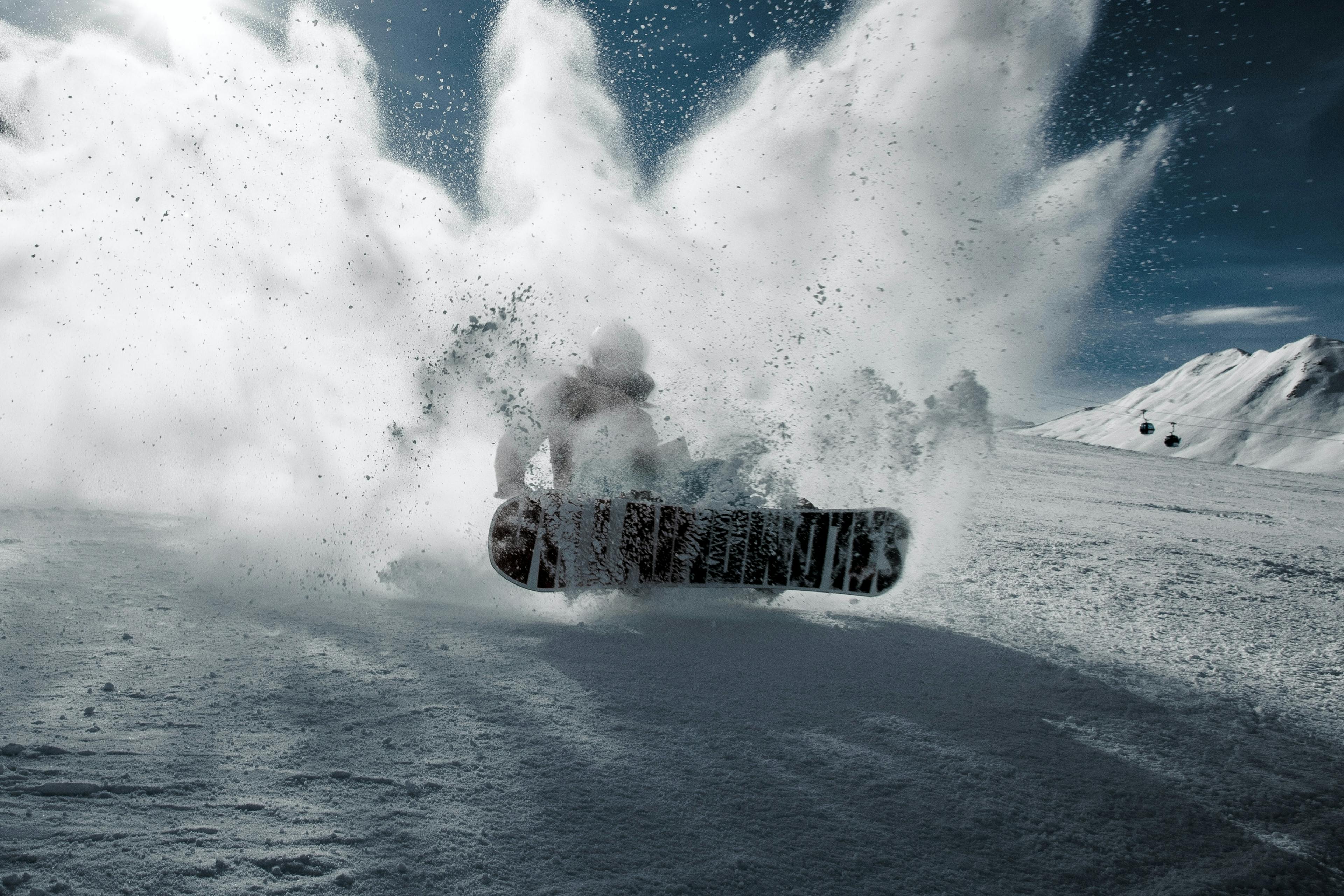 woman snowboarding and blasting snow