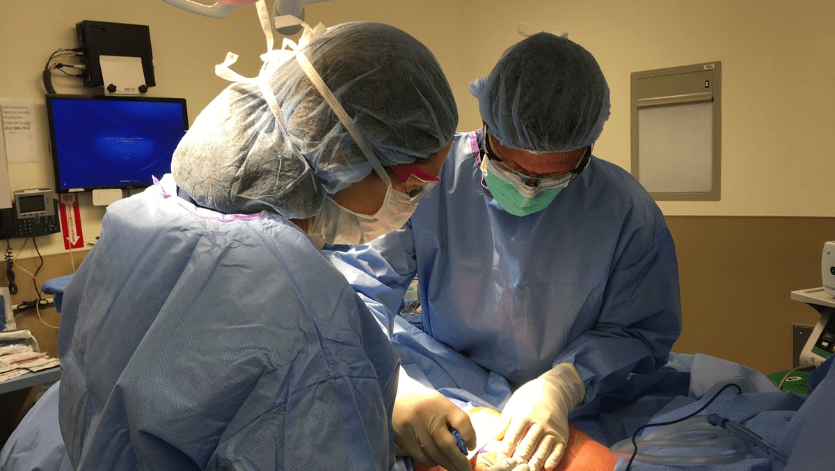 Anne and Ziv Peled carrying out surgery in an operating room