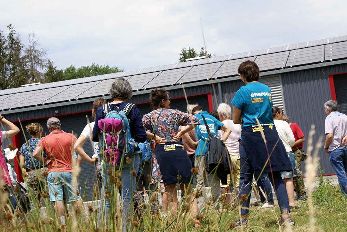 Sociétaires d'Enercoop AURA devant une toiture photovoltaïque à Loubeyrat