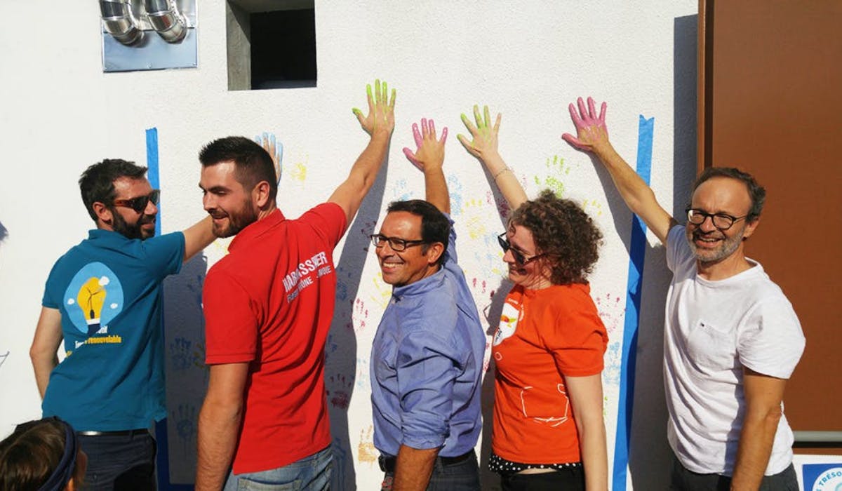 Membres de la société citoyenne touchant le mur avec leurs mains remplies de peinture
