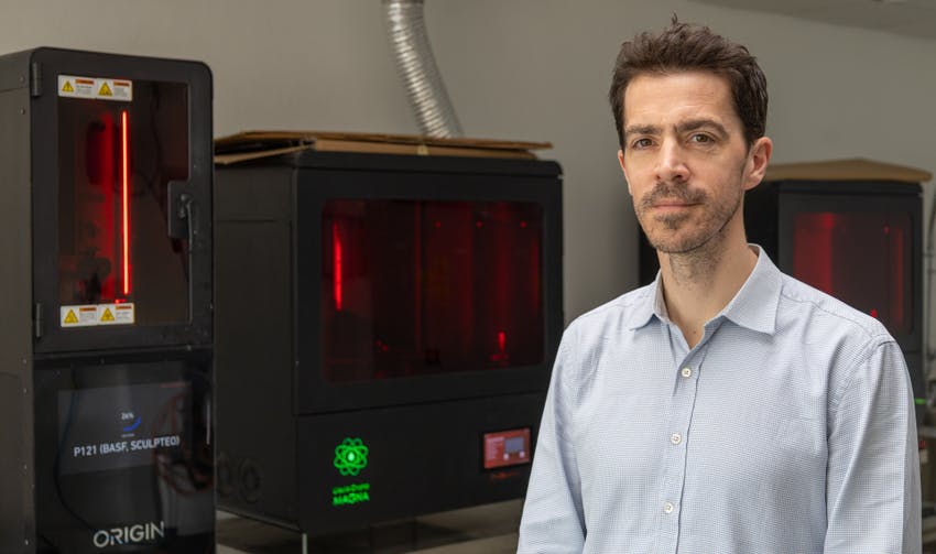 photo de Nicolas Mathian de l'entreprise Sculpteo, avec des machines d'impression 3D en arrière plan