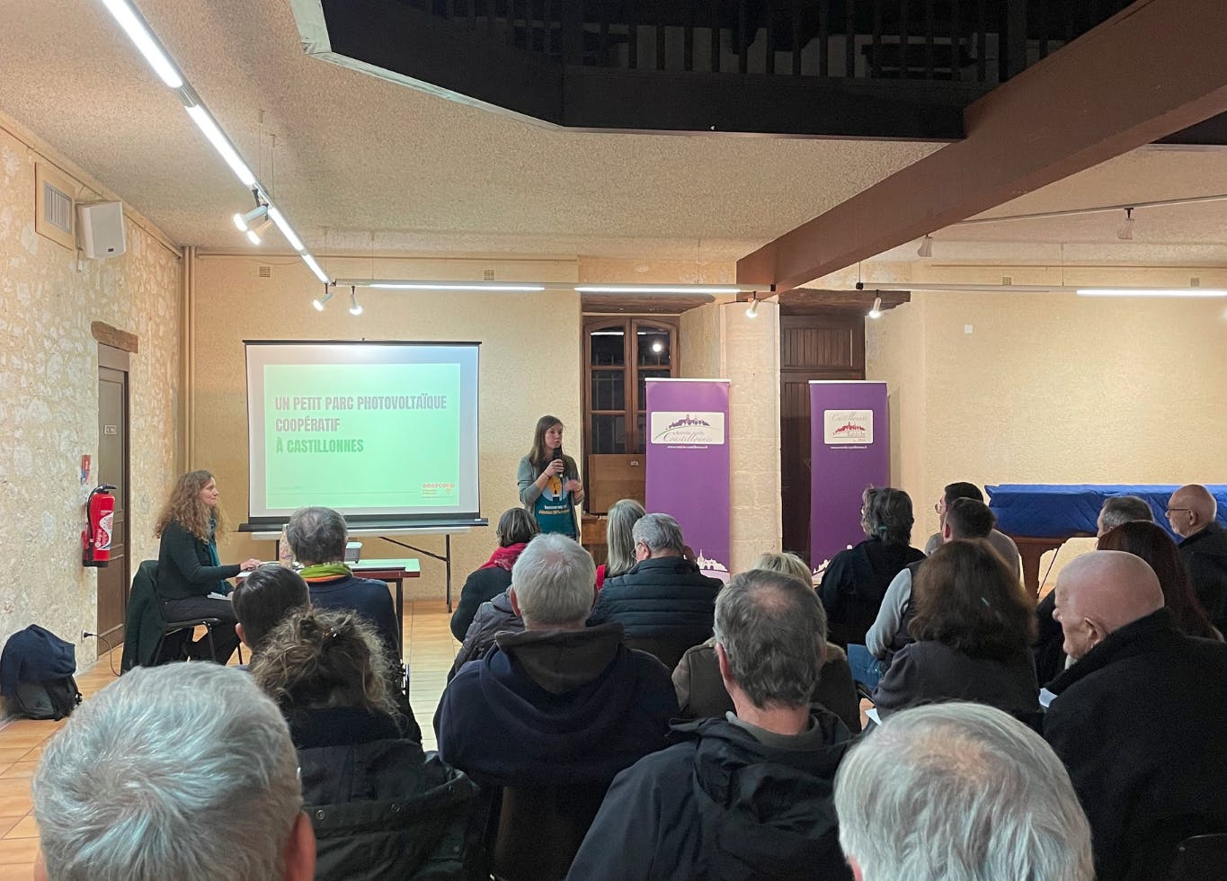 Photo de Morgane Bénard, responsable du pole énergie d'Enercoop Nouvelle-Aquitaine, qui présente le proejt du parc de La Douyne devant une trentaine de personnes