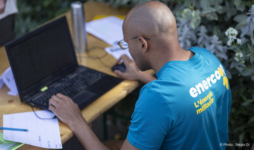 personne avec un t-shirt Enercoop travaillant sur un ordinateur portable