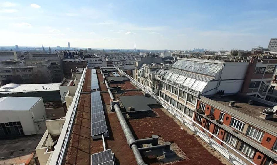 Les panneaux solaires d'une toiture sous un ciel bleu, l'horizon en arrière plan