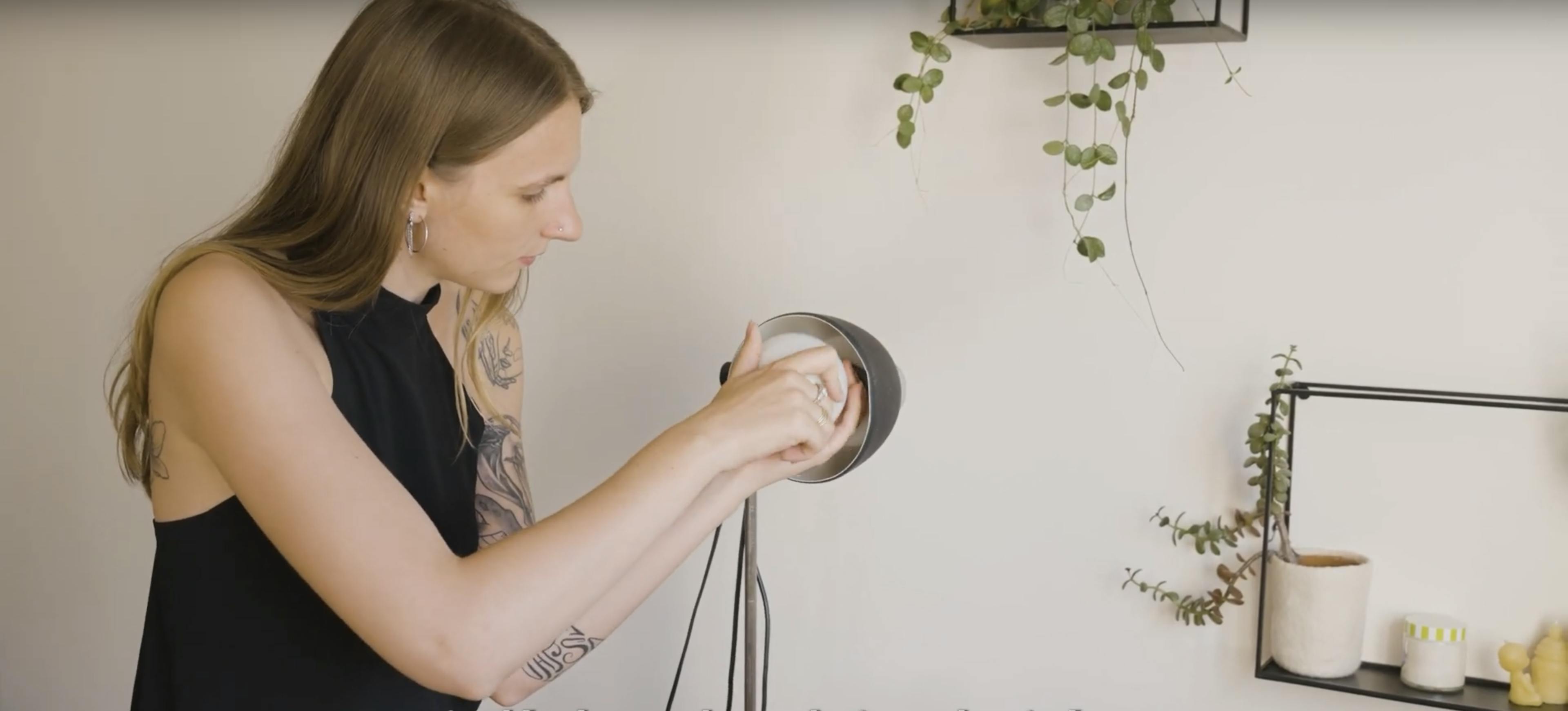 Femme changeant l'ampoule d'un luminaire