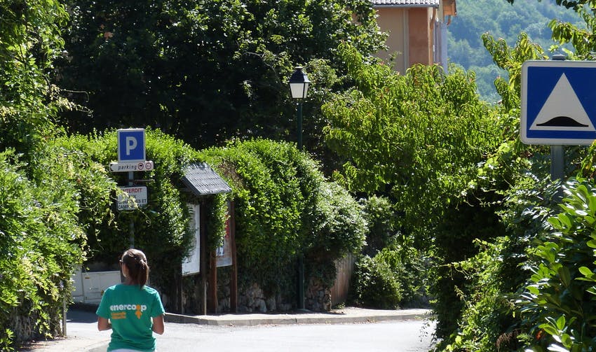personne avec un tshirt Enercoop marchant de dos dans un environnement végétalisé