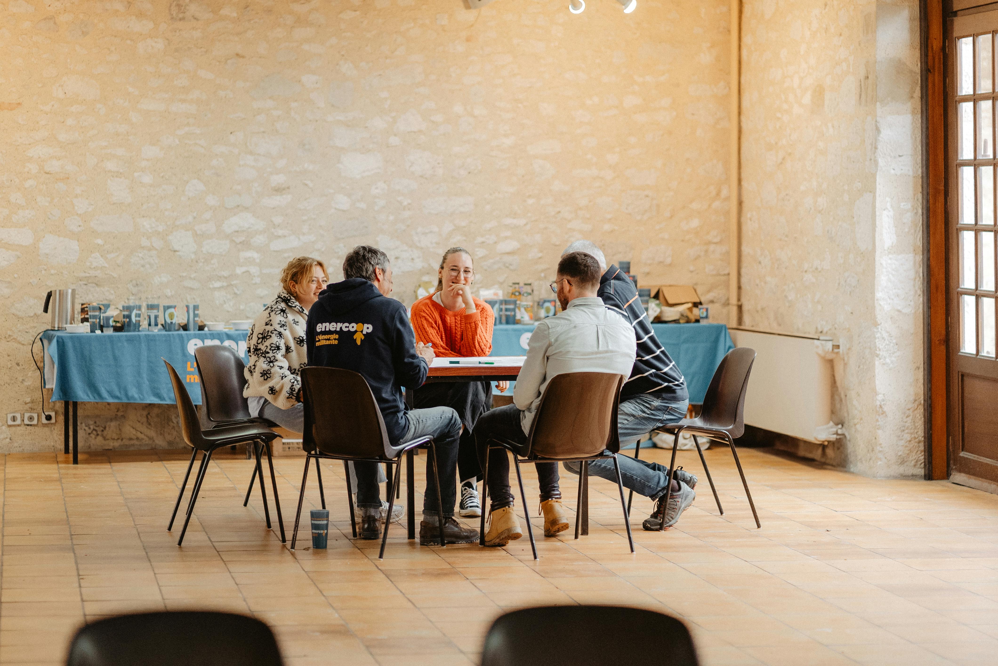 Un groupe de sociétaires et d'habitant.e.s de Castillonnès assis en rond. Ils et elles discutent avec des salarié.e.s de Cirena lors de la recontre 10joncteuse d'Enercoop Nouvelle-Aquitaine