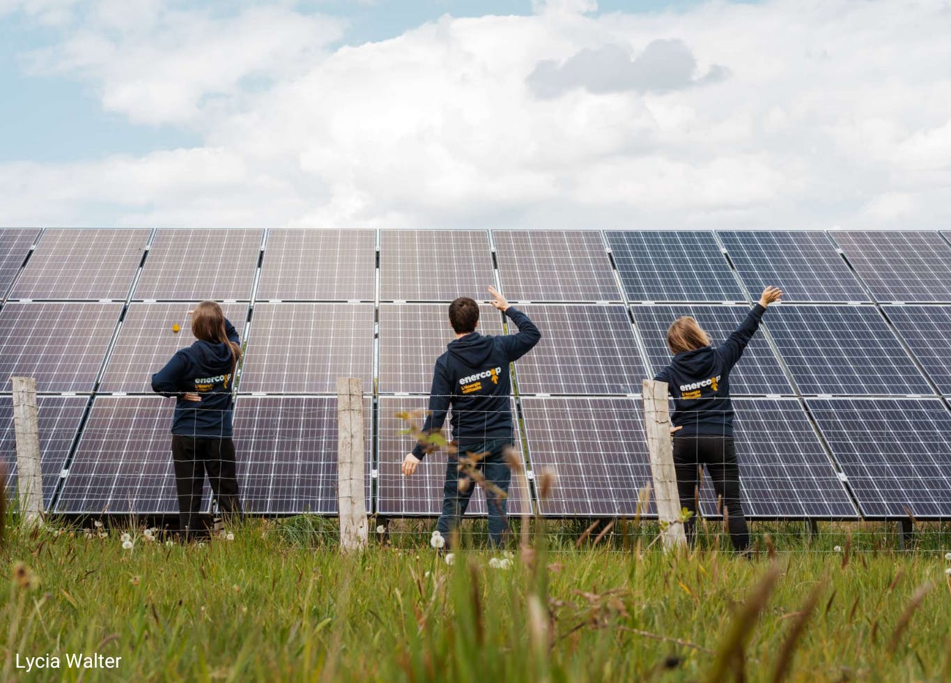 Photo de 3 salarié.e.s d'Enercoop nouvelle-Aquitaine devant un parc solaire d'un producteur d'énergie qui approvisionne Enercoop