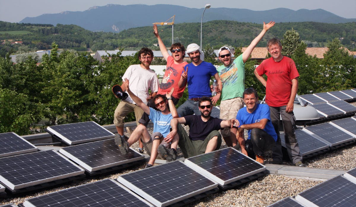 Acteurs du projet Soleil Marguerite posant en groupe devant les panneaux solaires 
