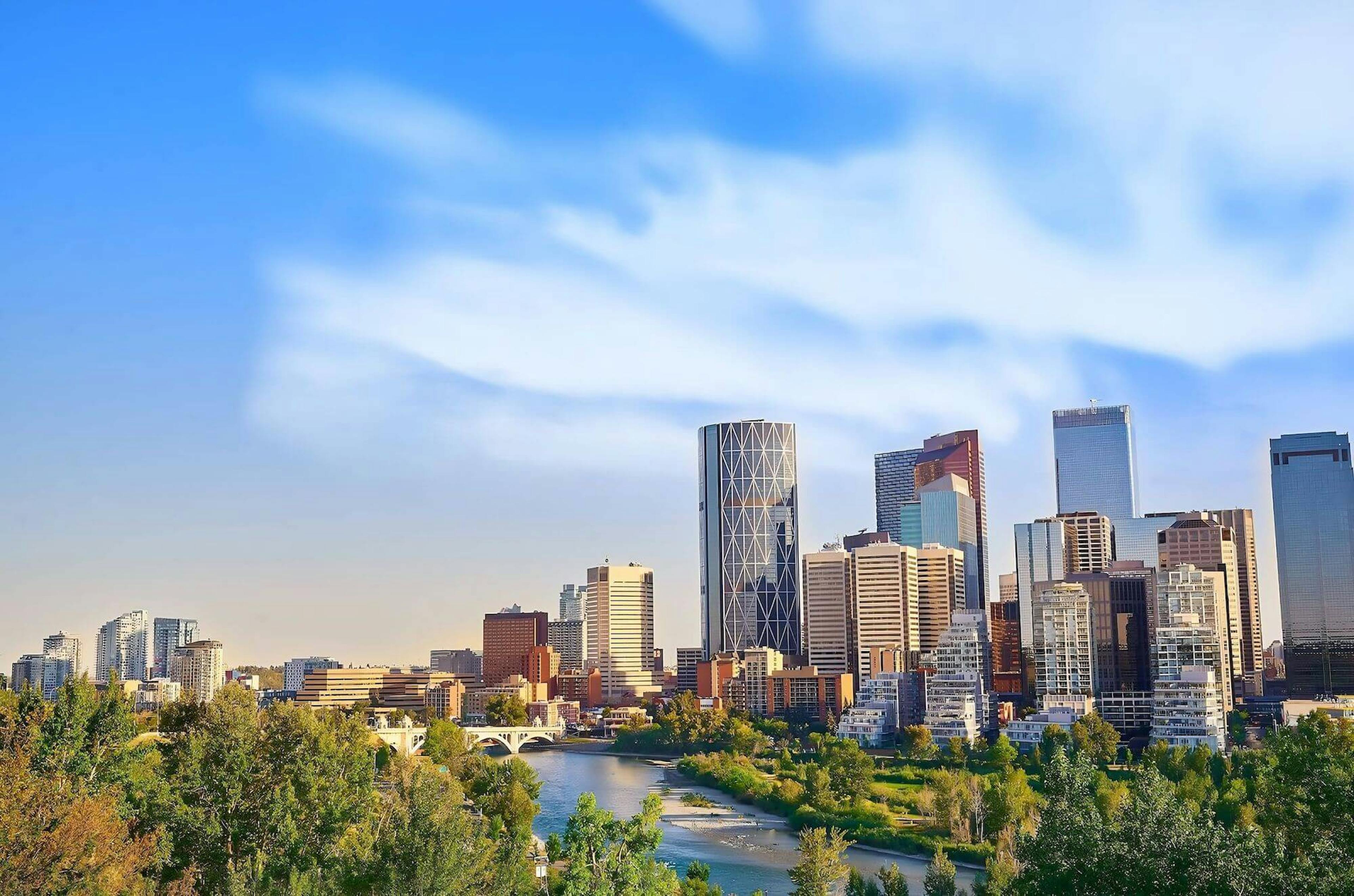 Calgary skyline under a blue sky, centered on the Bow Tower.